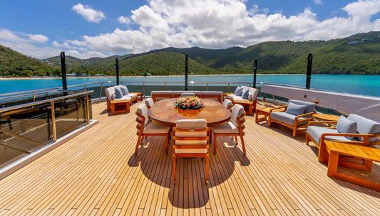 a table and chairs on a deck overlooking a body of water aboard SCOTT FREE Yacht for Charter