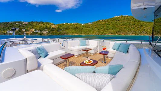 a large white lounge chair on a deck overlooking a large body of water aboard SCOTT FREE Yacht for Charter