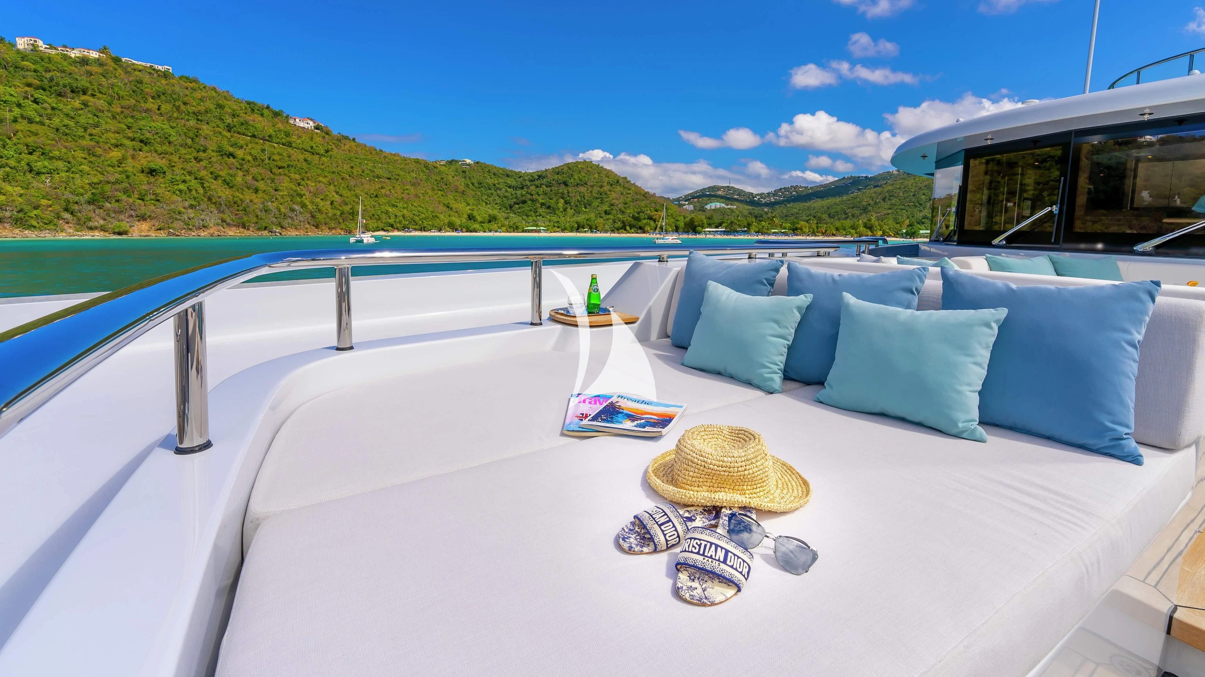 a large white bed with blue pillows on it aboard SCOTT FREE Yacht for Charter
