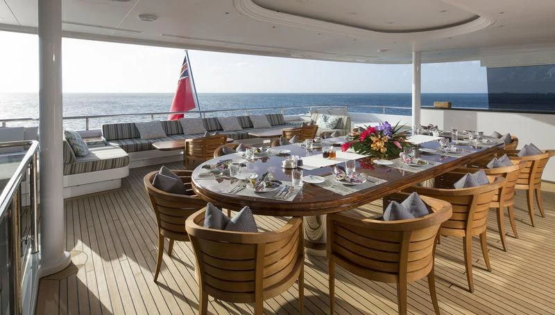a table set for a meal on a deck overlooking the ocean aboard SCOTT FREE Yacht for Charter