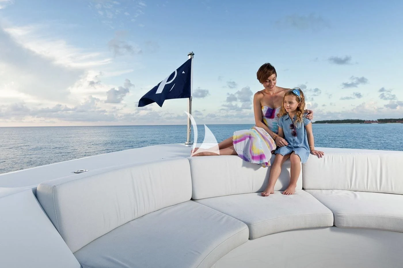 a man and a woman sitting on a couch with a flag on the back aboard SCOTT FREE Yacht for Charter