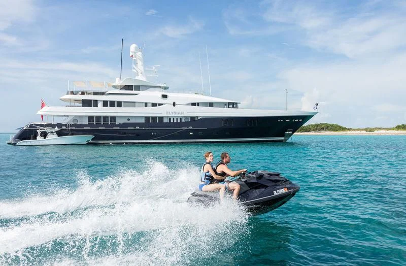 a couple of people on a boat in the water with a large boat in the background aboard SCOTT FREE Yacht for Charter