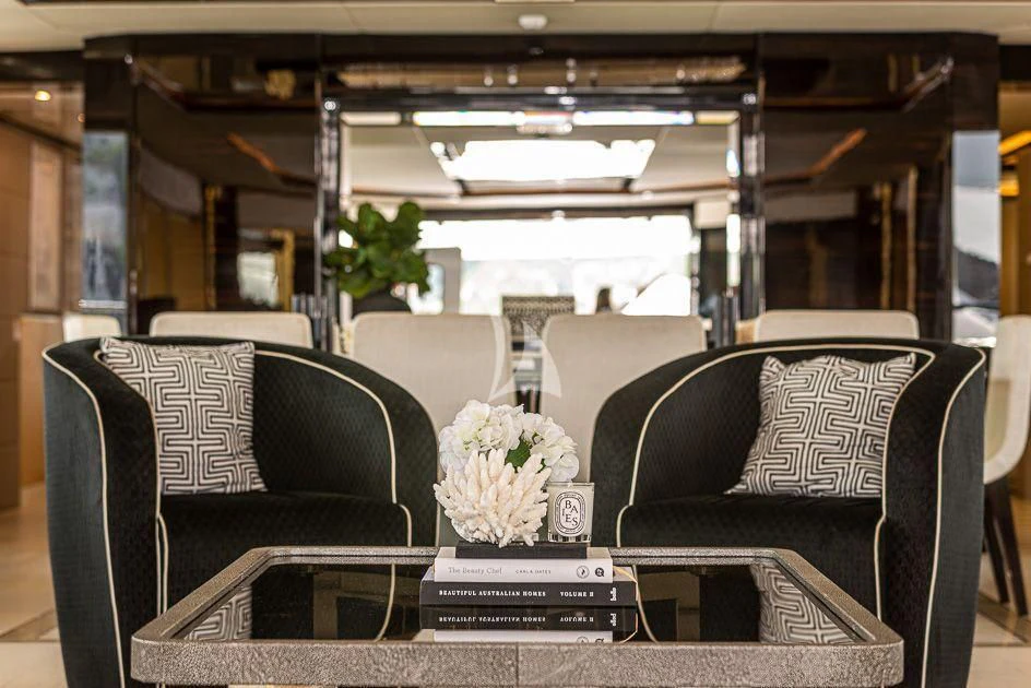 a couple of leather couches in a room with a table and chairs aboard GHOST II Yacht for Sale