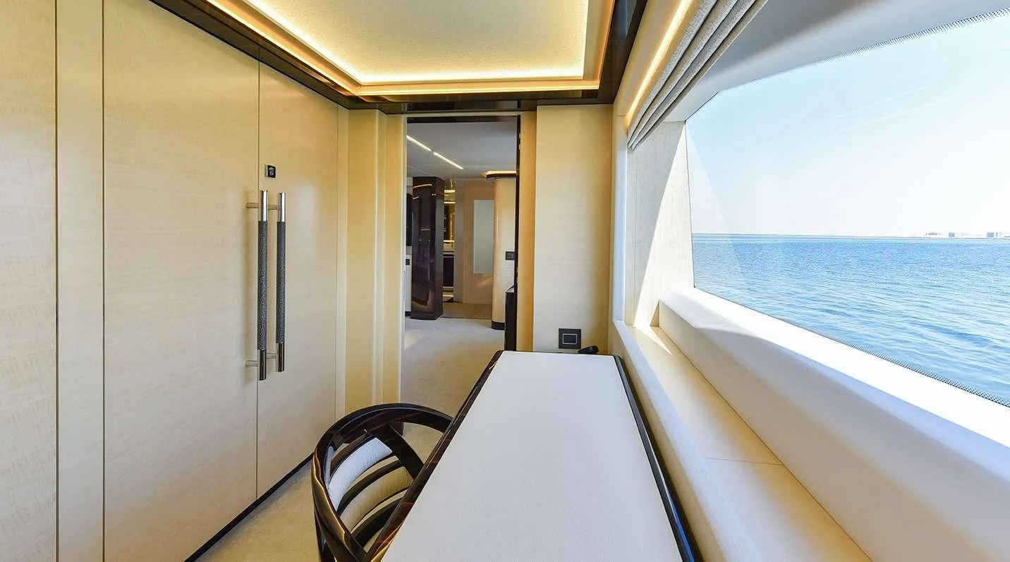 a room with a chair and a table and a window aboard GHOST II Yacht for Sale