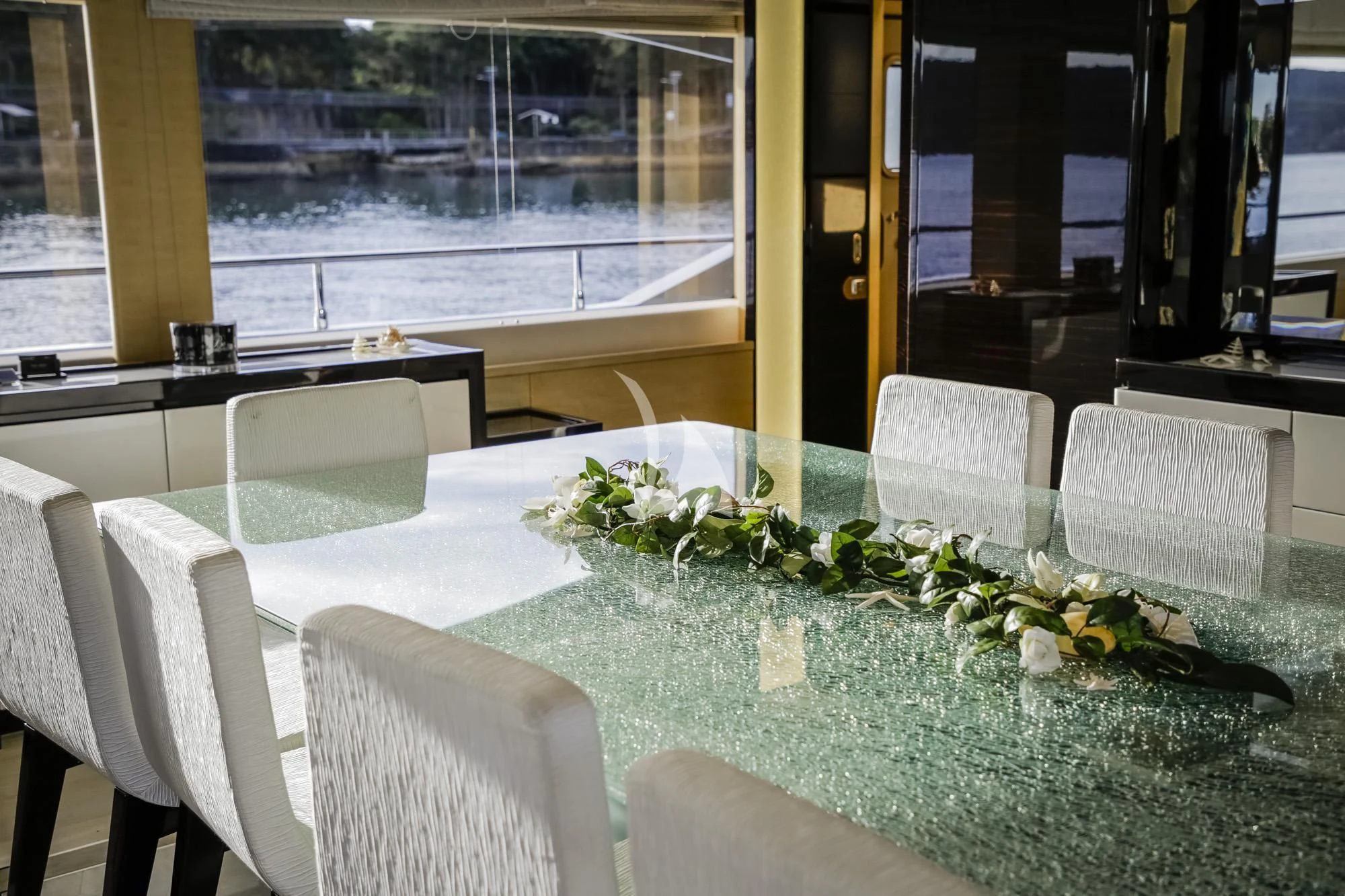 a table with chairs and plants on it aboard GHOST II Yacht for Sale