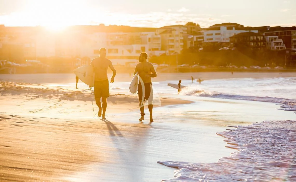 surfers walking on the beach aboard GHOST II Yacht for Sale
