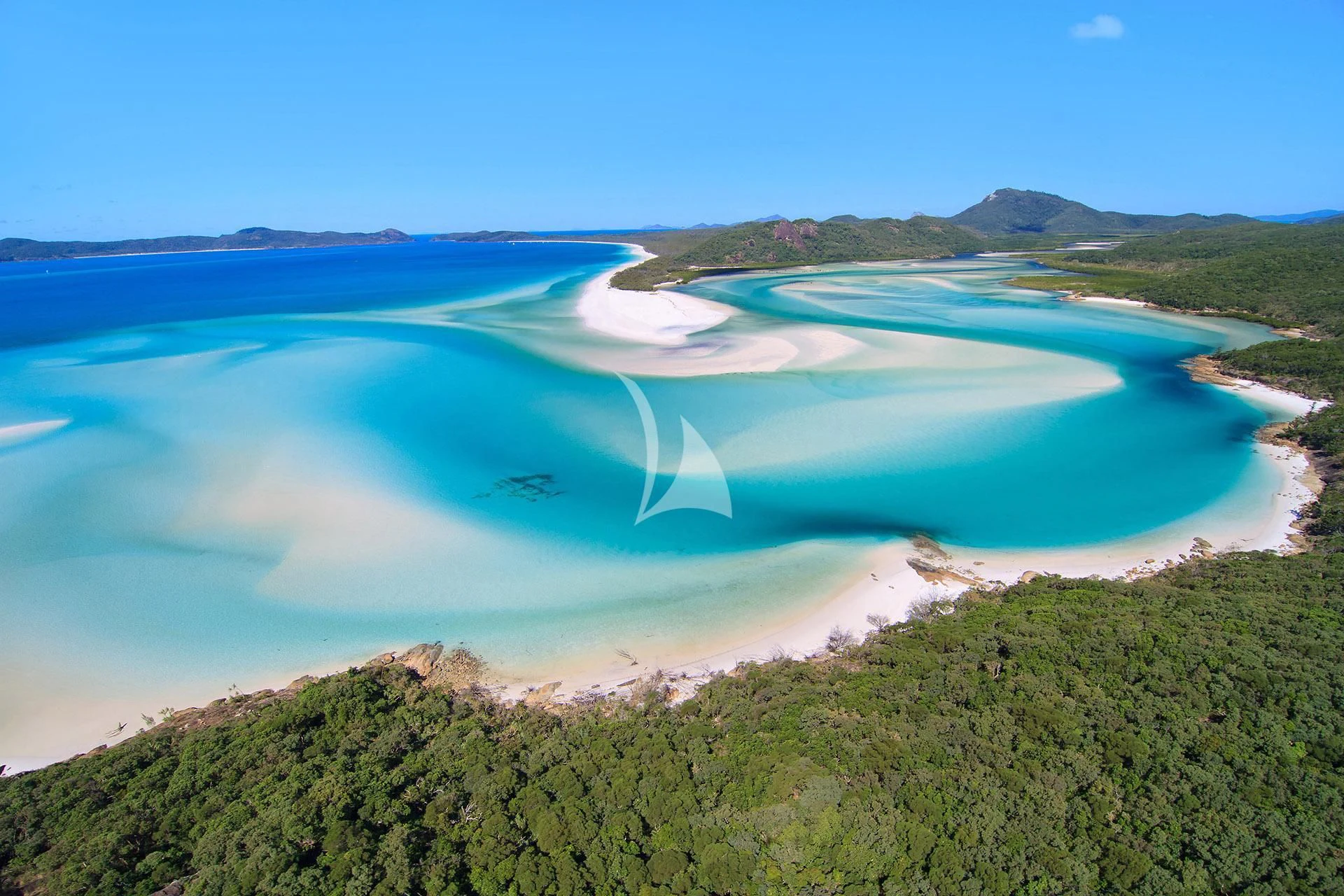 a body of water with land around it with Whitehaven Beach in the background aboard GHOST II Yacht for Sale