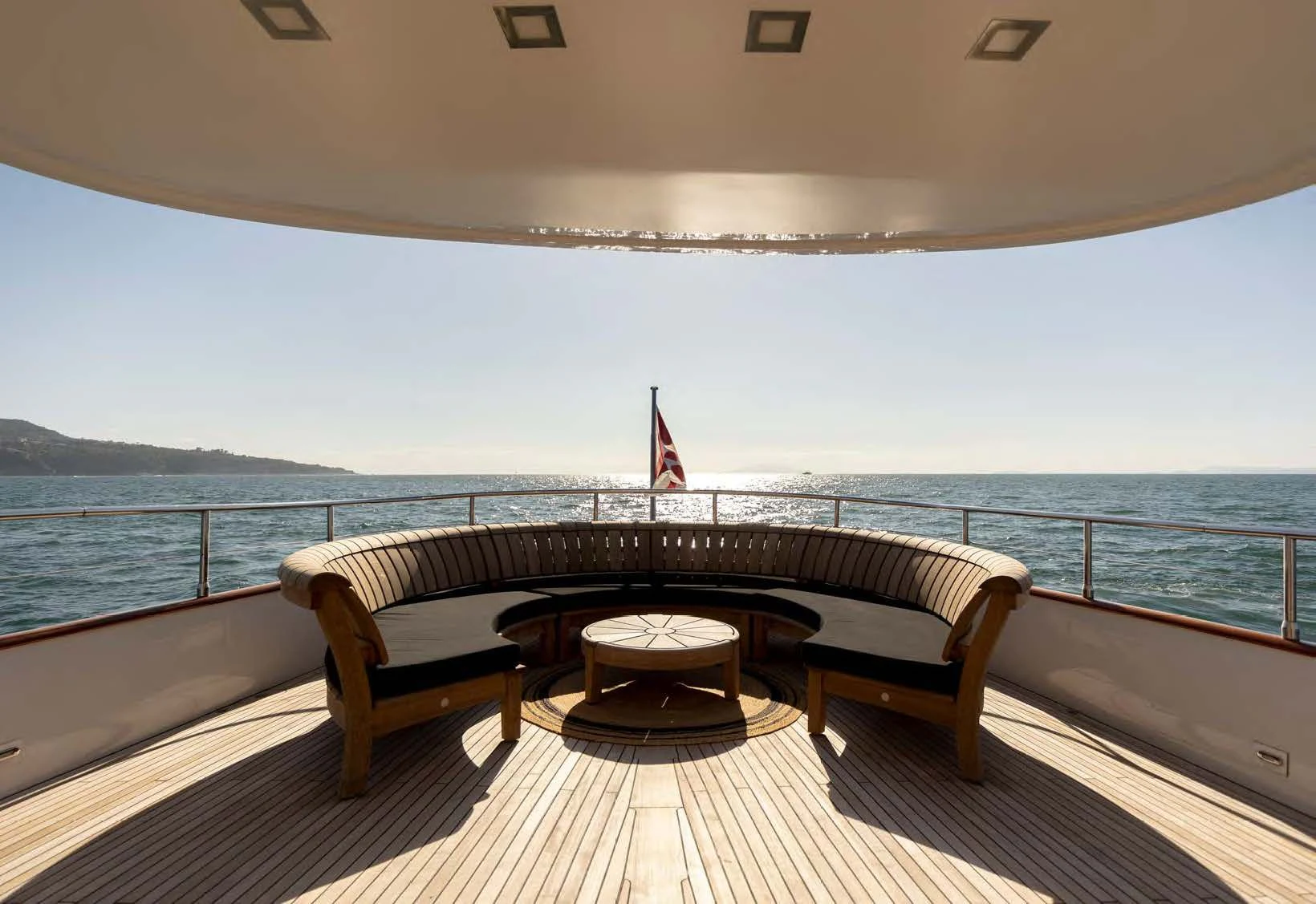 a table and chairs on a deck overlooking a body of water aboard SOUNION II Yacht for Sale