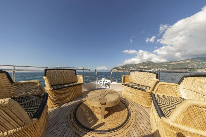 a deck with chairs and a table on it aboard SOUNION II Yacht for Sale