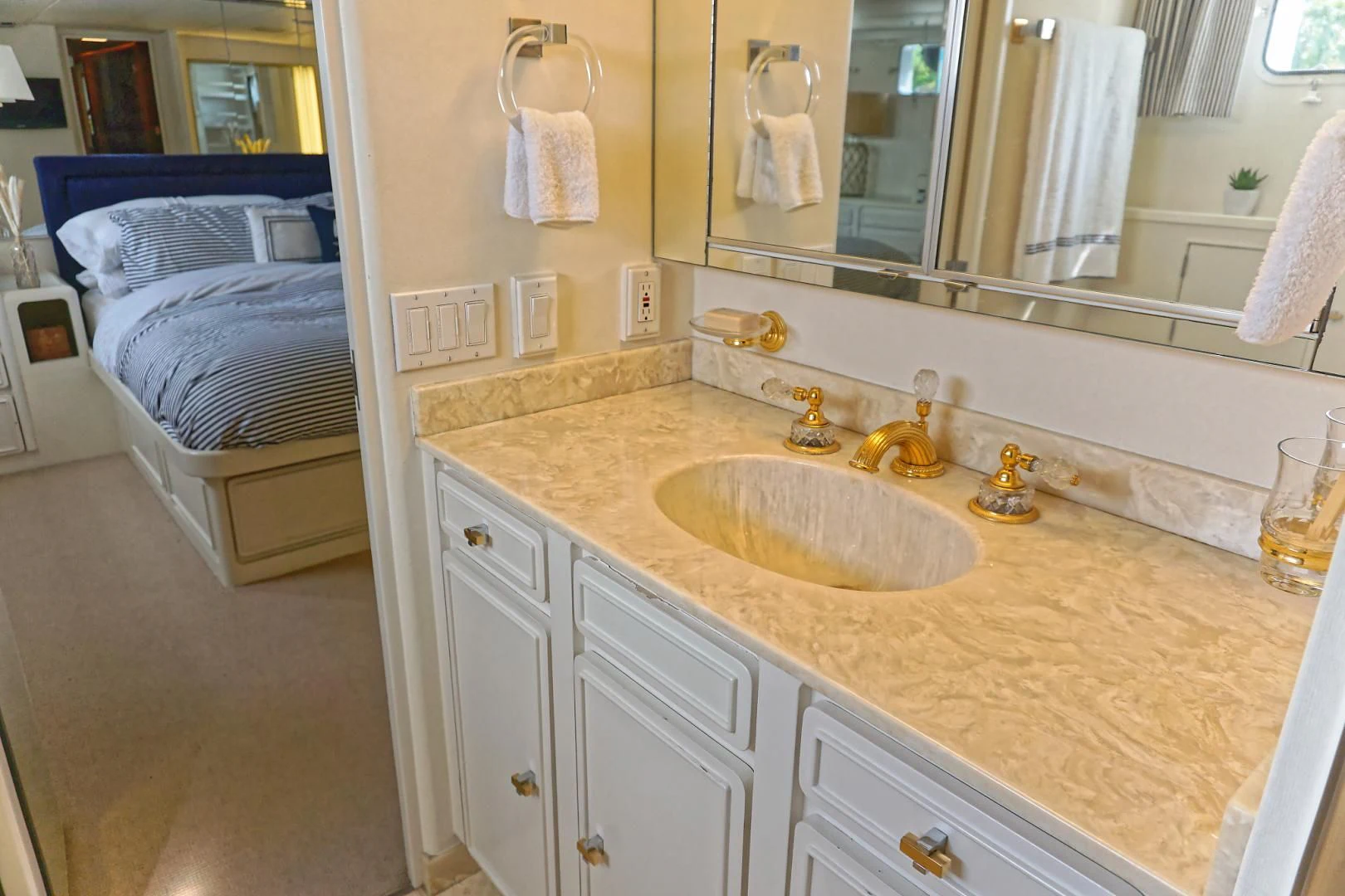 a bathroom with a sink and a bed aboard ENCORE V Yacht for Sale