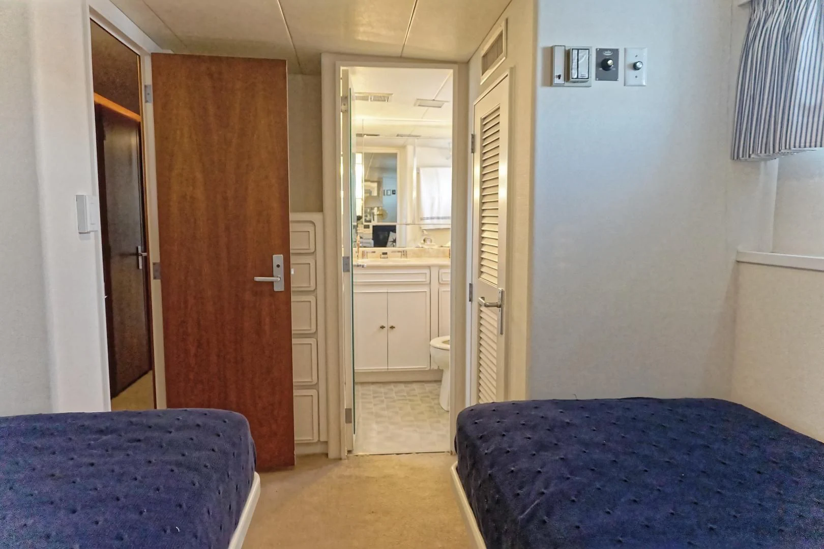 a bedroom with a blue bed aboard ENCORE V Yacht for Sale