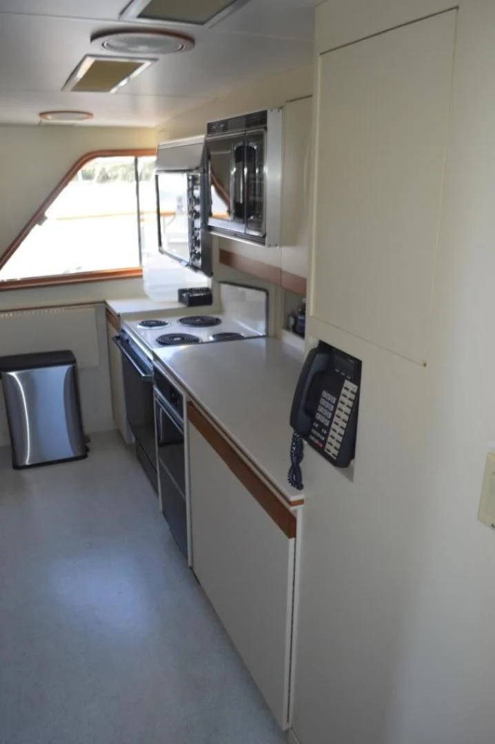 a small kitchen with a small refrigerator aboard ENCORE V Yacht for Sale