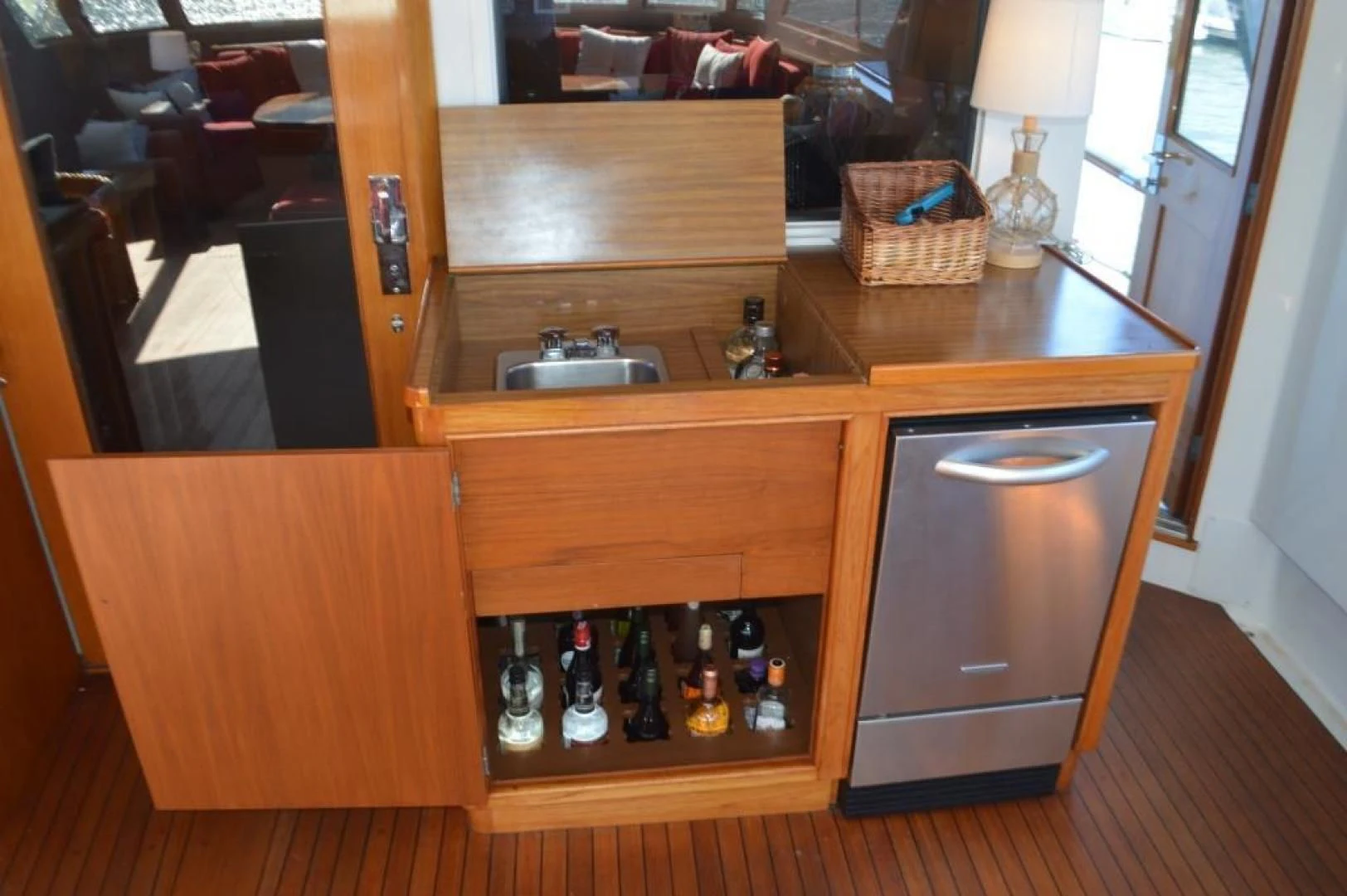a wooden cabinet with bottles of liquor on it aboard ENCORE V Yacht for Sale