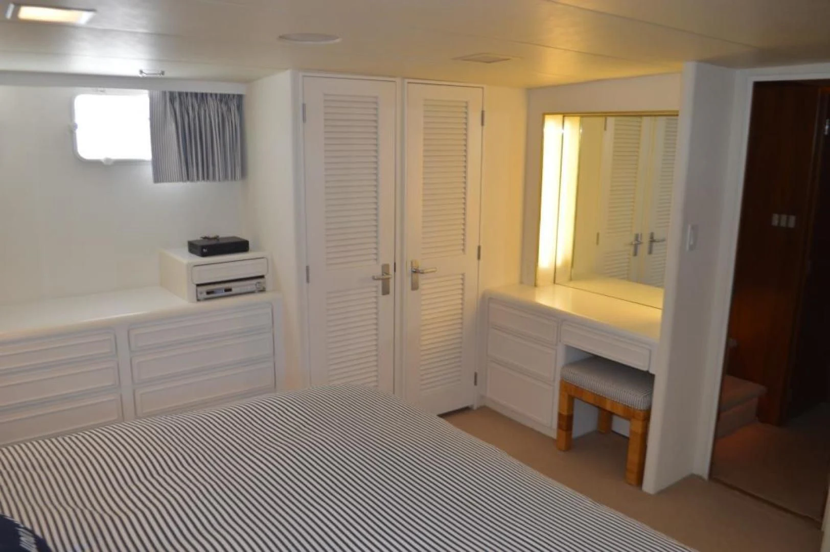 a bedroom with a bed and desk aboard ENCORE V Yacht for Sale