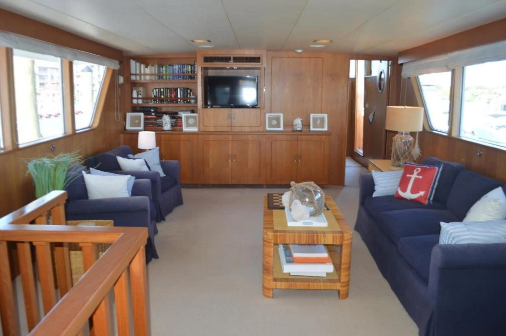 a living room with a blue couch and a coffee table aboard ENCORE V Yacht for Sale