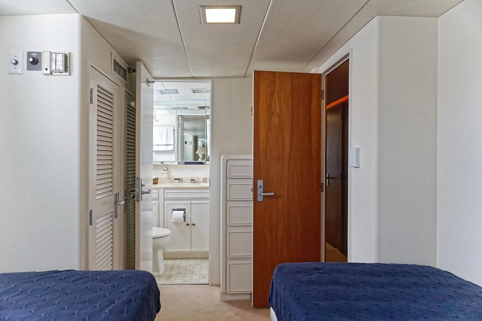 a bedroom with a blue bed aboard ENCORE V Yacht for Sale
