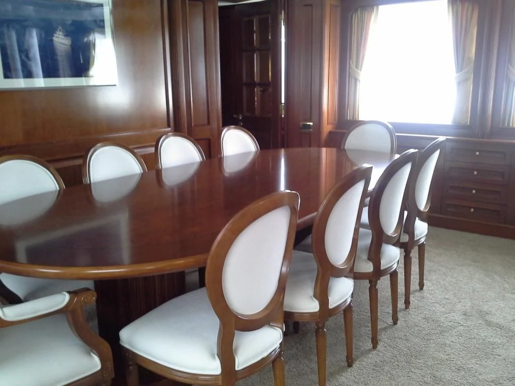 a room with a table chairs and a window aboard INOUIS Yacht for Charter