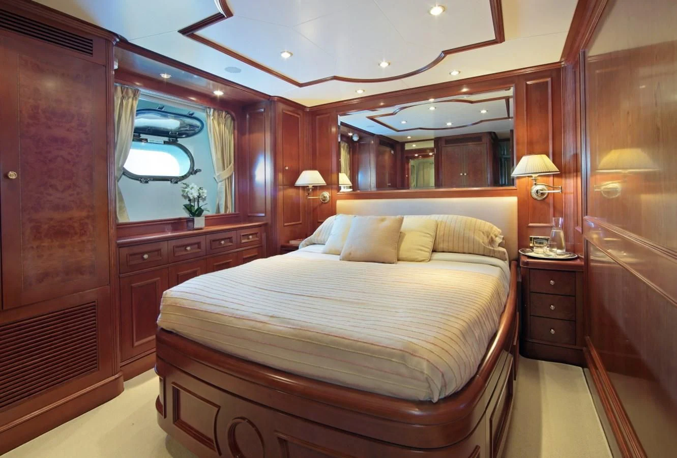 a bedroom with a bed and a mirror aboard INOUIS Yacht for Charter