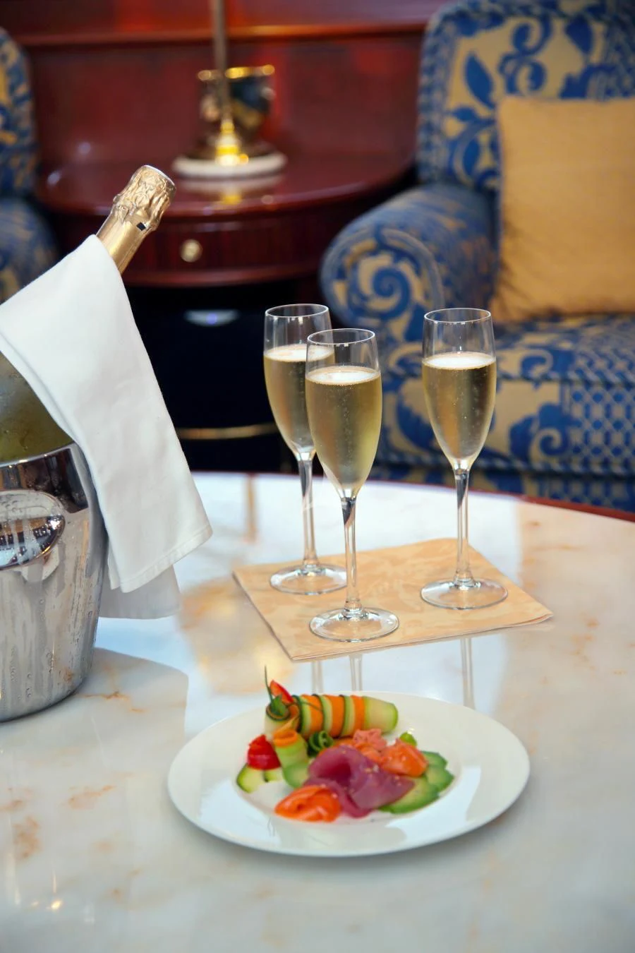 a table with a plate of food and glasses of wine aboard INOUIS Yacht for Charter