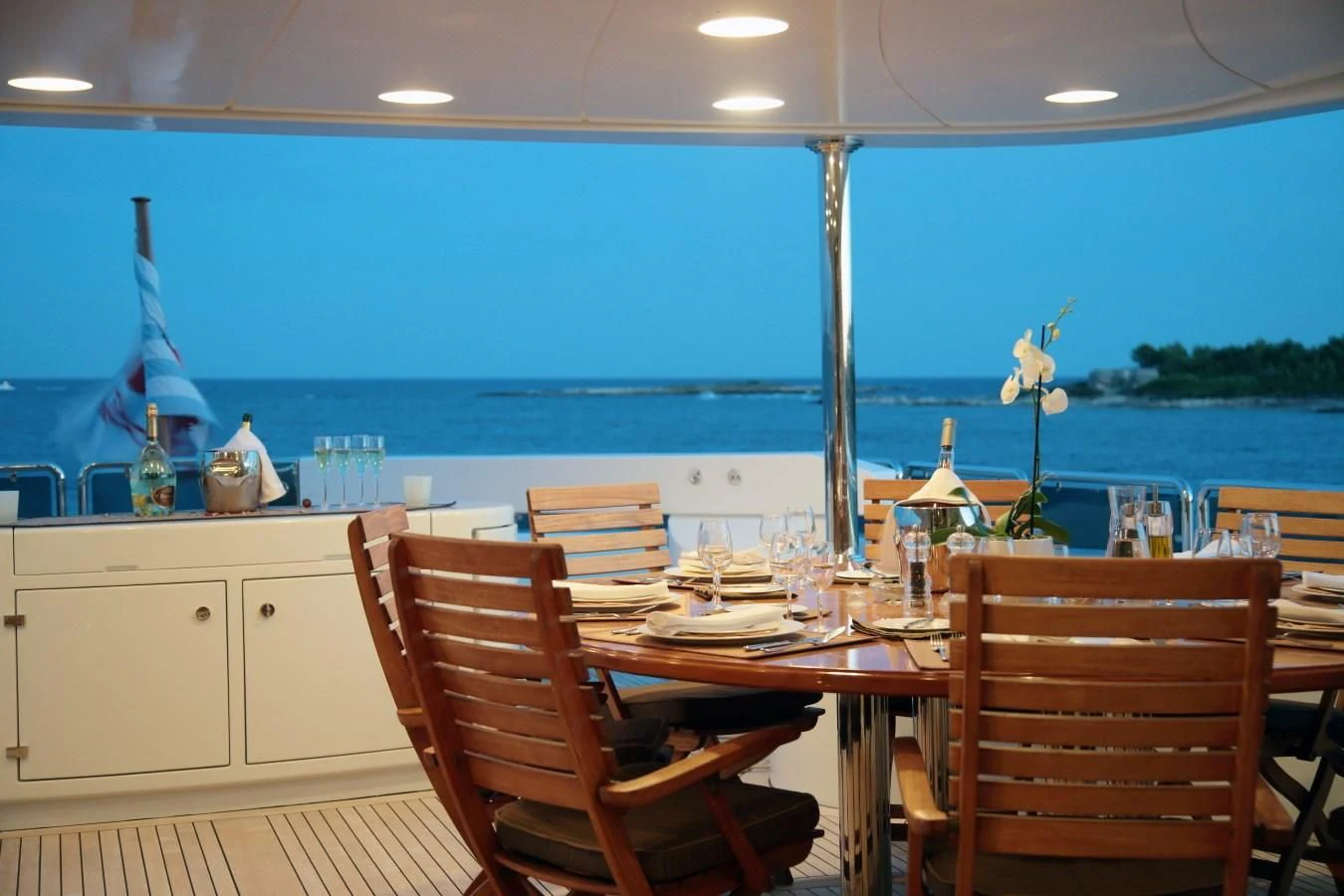 a dining table with chairs and a view of the ocean aboard INOUIS Yacht for Charter