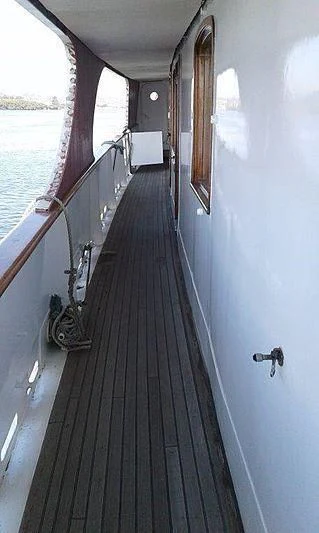 a long narrow hallway with a window aboard UTHINGO Yacht for Sale