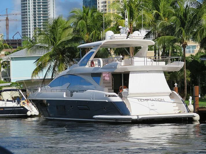 a large white boat in a harbor aboard TEMPTATION Yacht for Sale