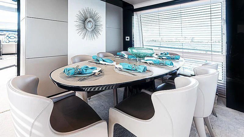 a dining table with chairs and a fan aboard TEMPTATION Yacht for Sale