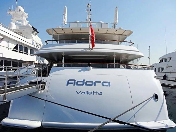 a large white boat with a red stripe on the front aboard ADORA Yacht for Sale