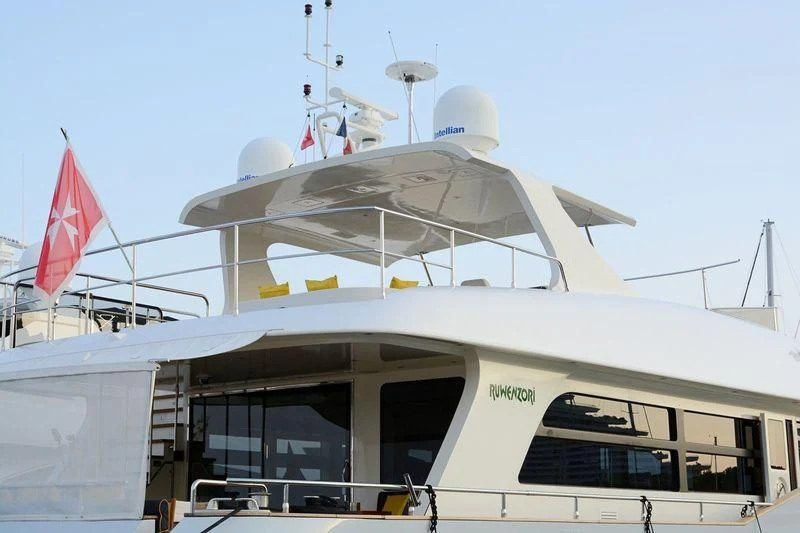 a boat with a flag on the front aboard MR GU Yacht for Sale