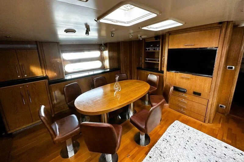 a room with a table and chairs aboard SONGBIRD OF LONDON Yacht for Sale