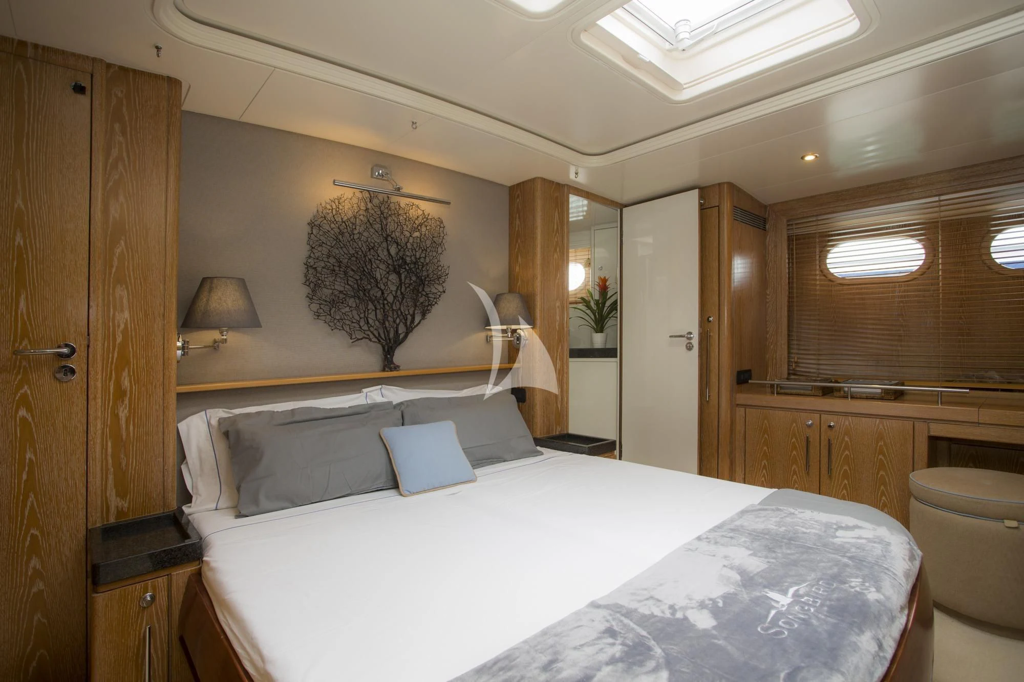 a bedroom with a bed and a wood cabinet aboard SONGBIRD OF LONDON Yacht for Sale
