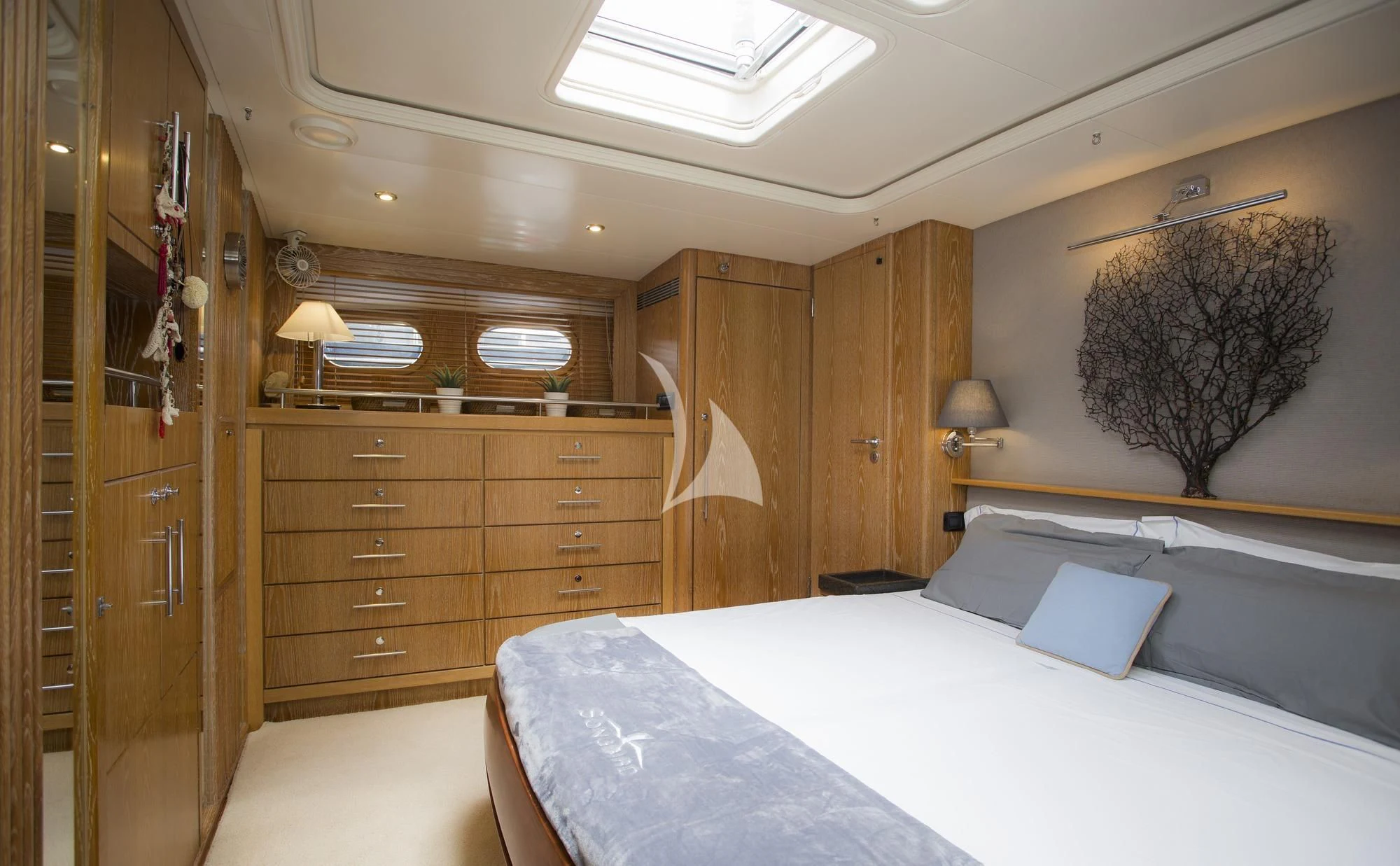 a bedroom with a bed and a dresser aboard SONGBIRD OF LONDON Yacht for Sale