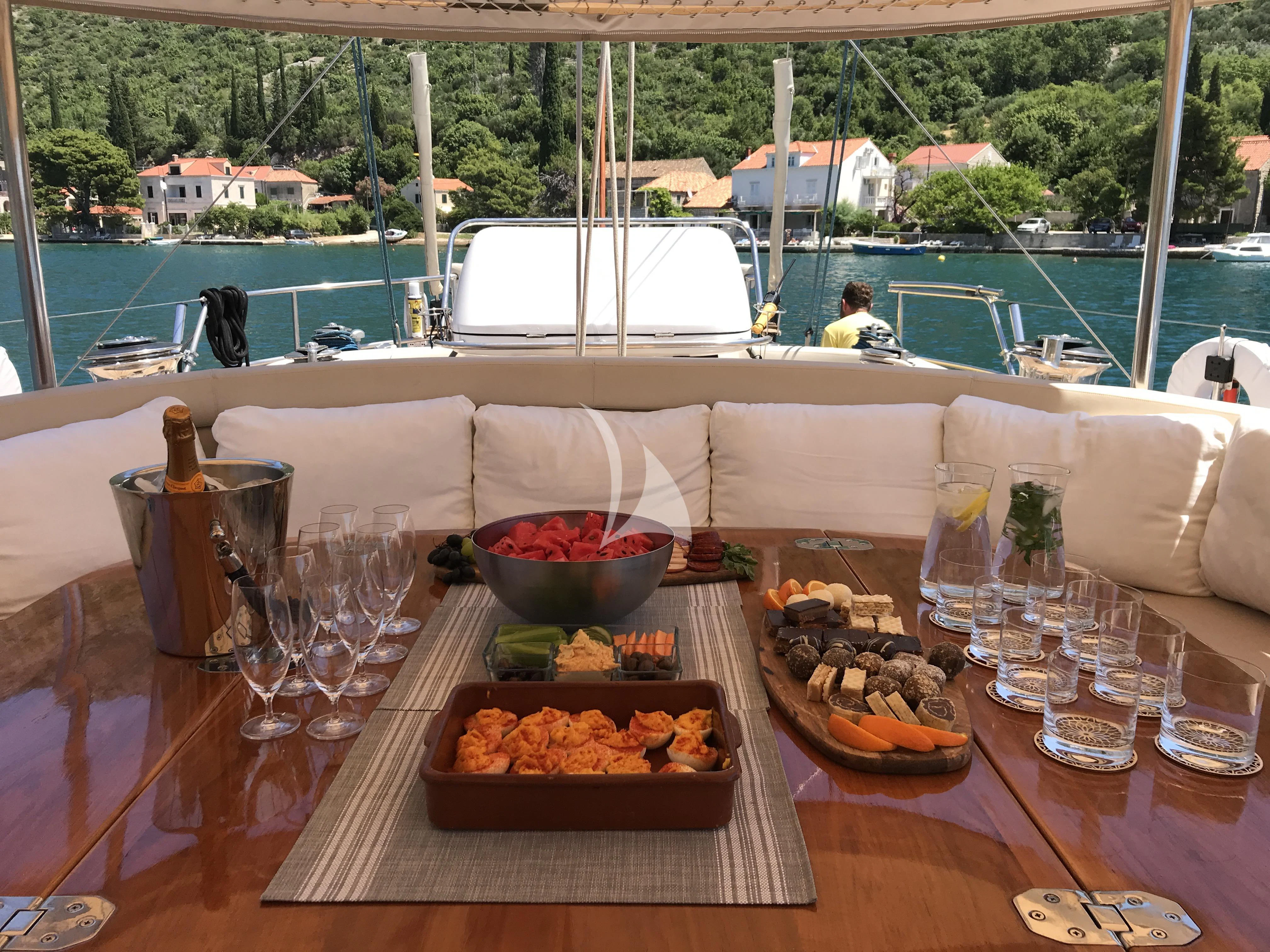 a table with food and glasses on it aboard SONGBIRD OF LONDON Yacht for Sale