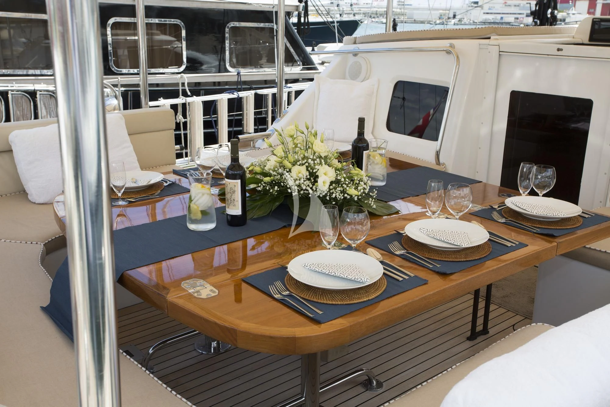 a table with plates and wine bottles aboard SONGBIRD OF LONDON Yacht for Sale