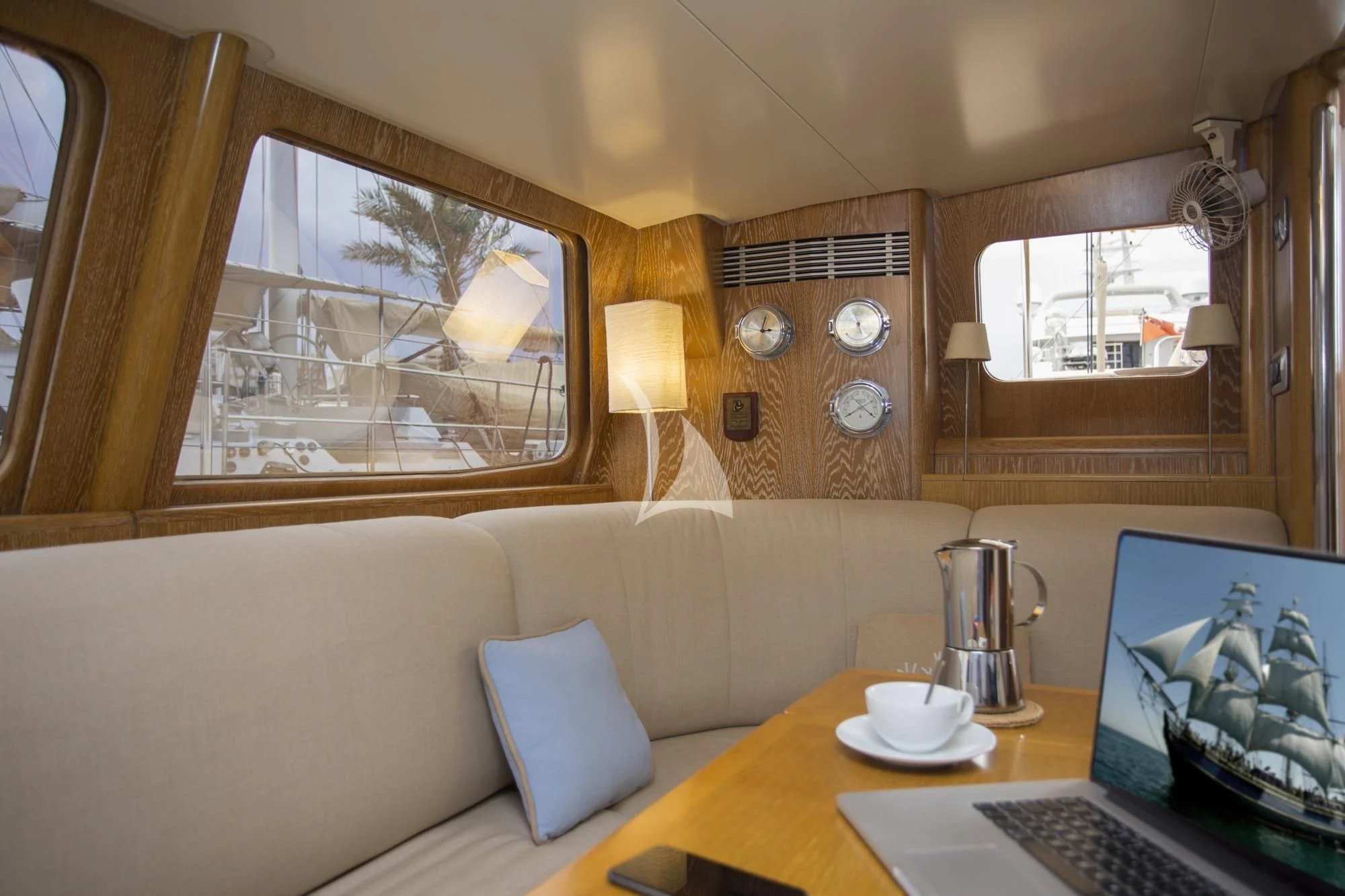 a living room with a laptop and a coffee table aboard SONGBIRD OF LONDON Yacht for Sale