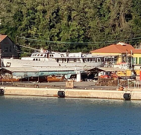 a large white boat docked at a pier aboard EUTOPIA Yacht for Sale