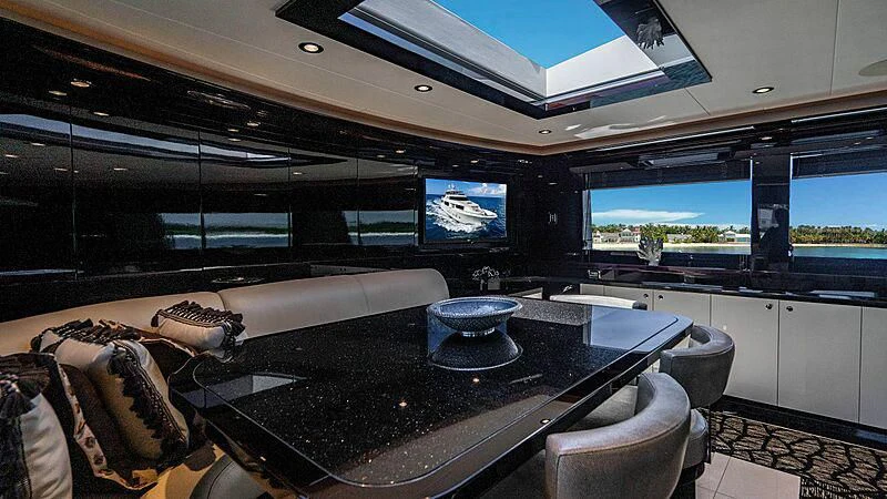 a modern looking kitchen with a large black table and chairs aboard BLACK SWAN Yacht for Sale