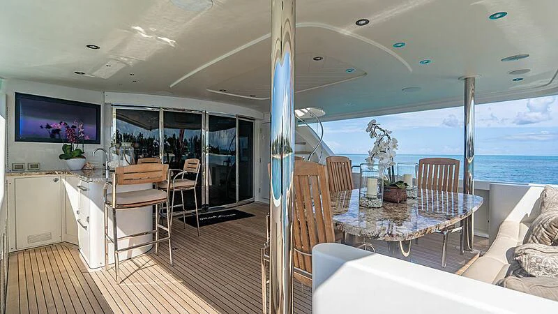 a large room with a table and chairs and a tv aboard BLACK SWAN Yacht for Sale
