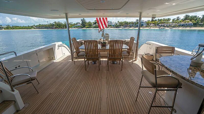 a deck with chairs and tables on it aboard BLACK SWAN Yacht for Sale