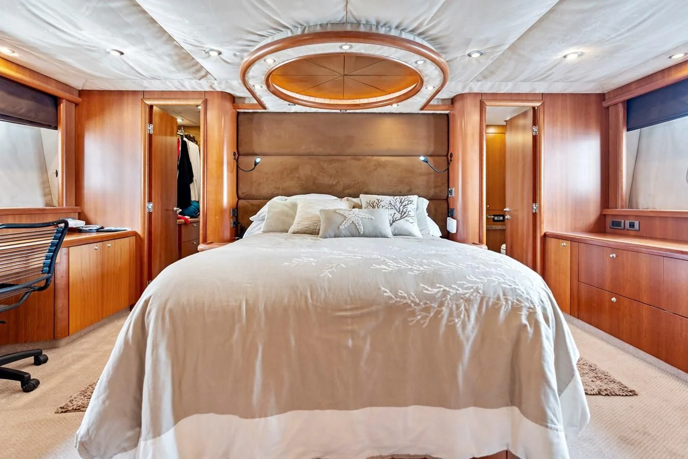 a bed with a chandelier above it aboard PERSISTENCE Yacht for Sale