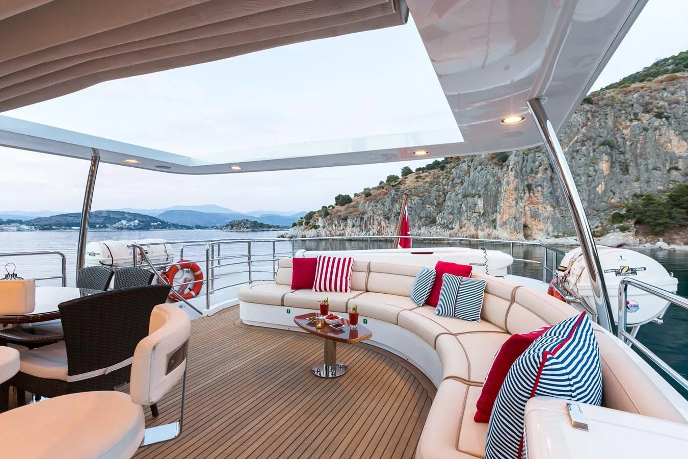 a deck with a view of the ocean and mountains aboard REBECCA V Yacht for Sale