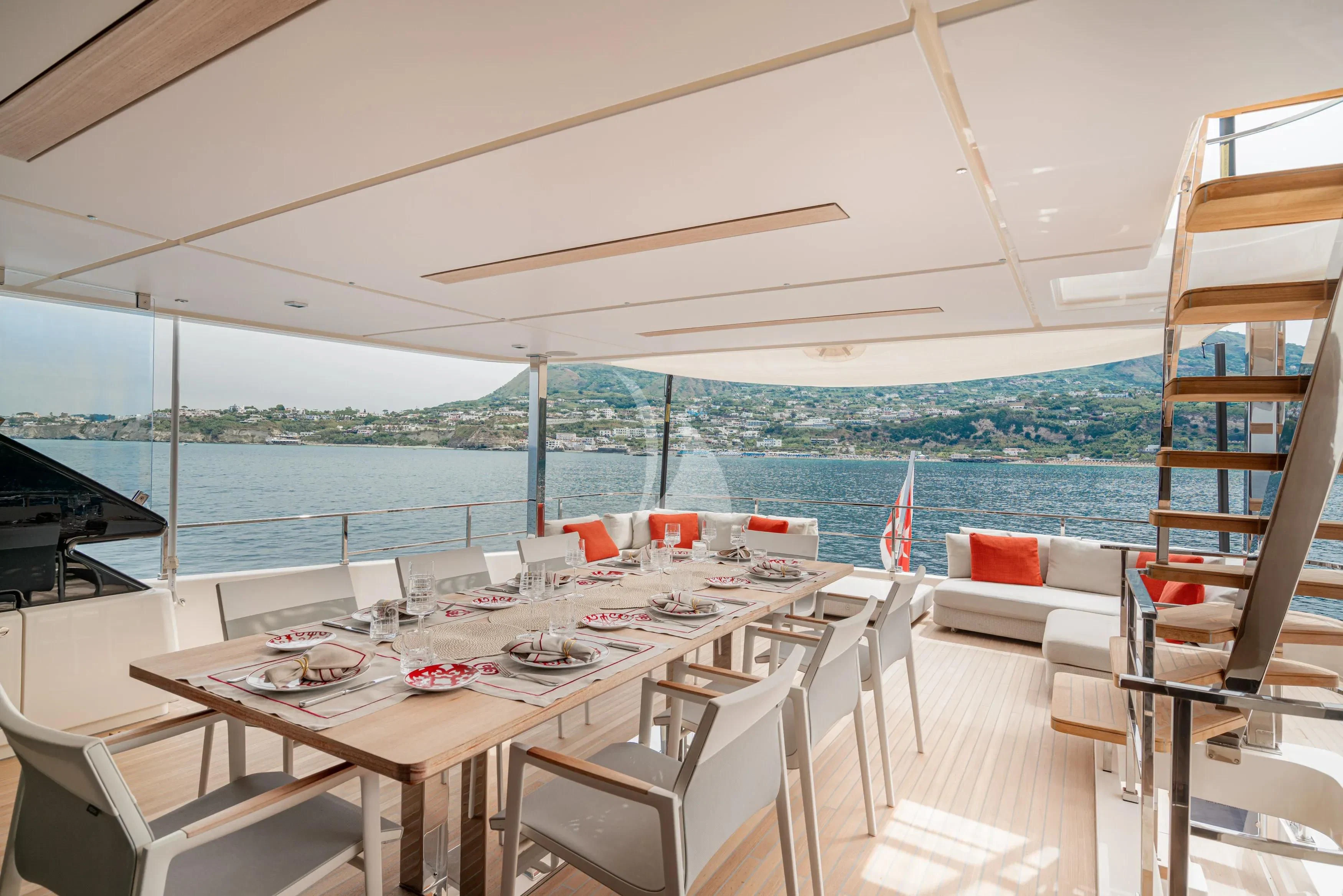a room with a table chairs and a view of the ocean aboard DIANA II Yacht for Sale