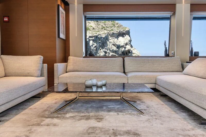 a living room with a large glass coffee table and a large window aboard DIANA II Yacht for Sale
