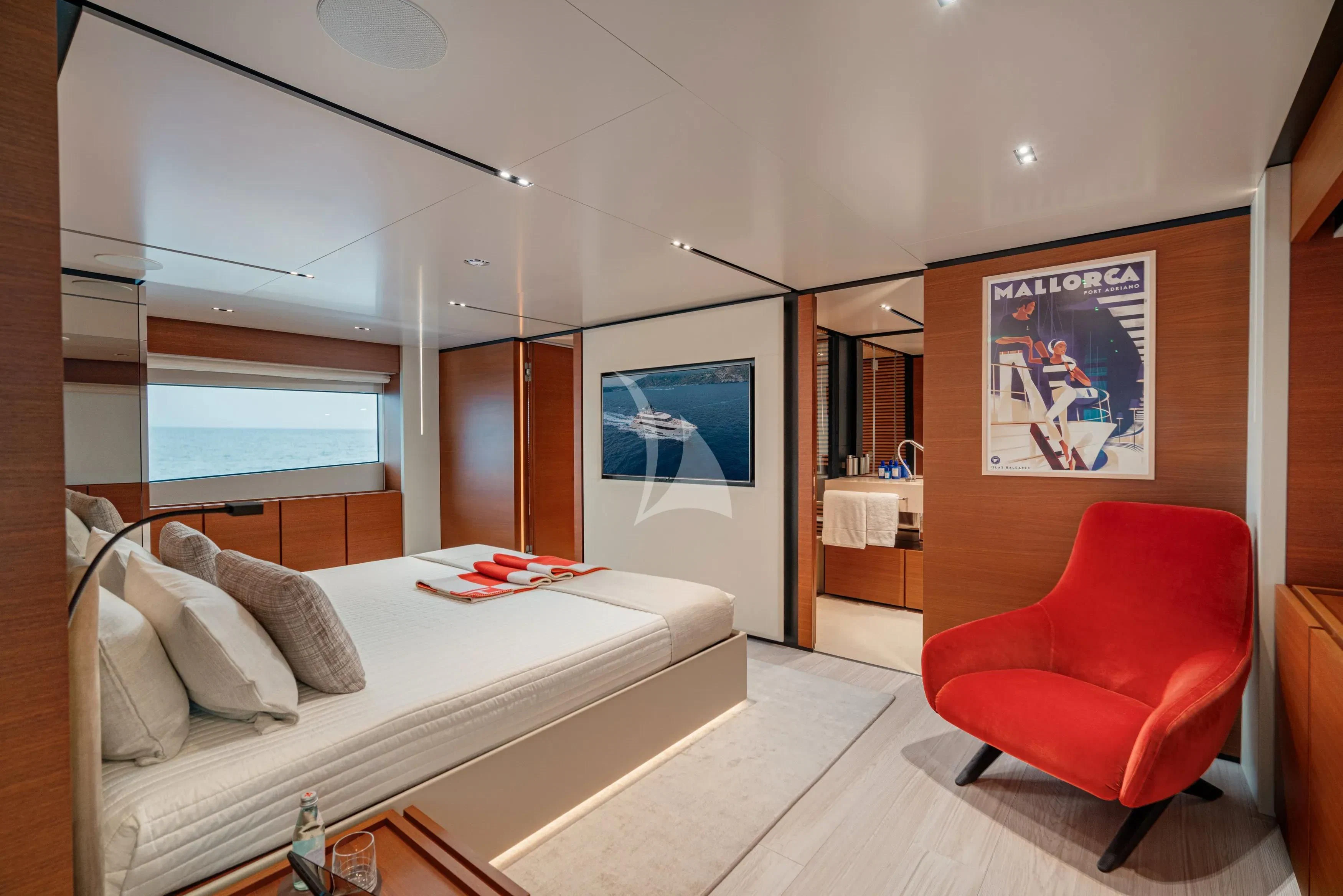 a bedroom with a red chair aboard DIANA II Yacht for Sale