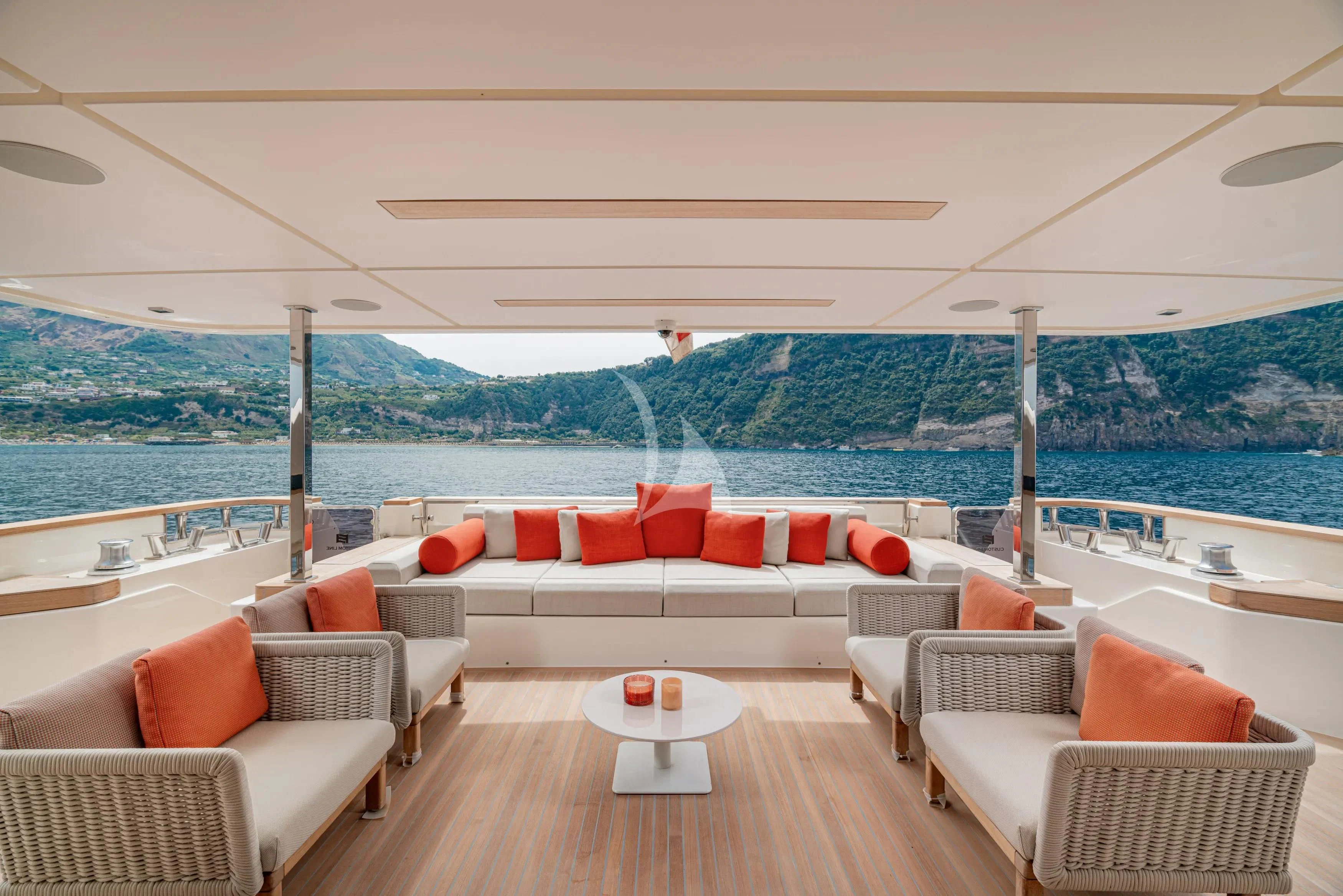 a lounge area with a large body of water in the background aboard DIANA II Yacht for Sale