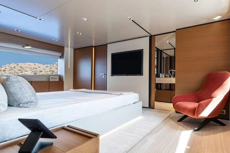a bedroom with a bed and a chair aboard DIANA II Yacht for Sale
