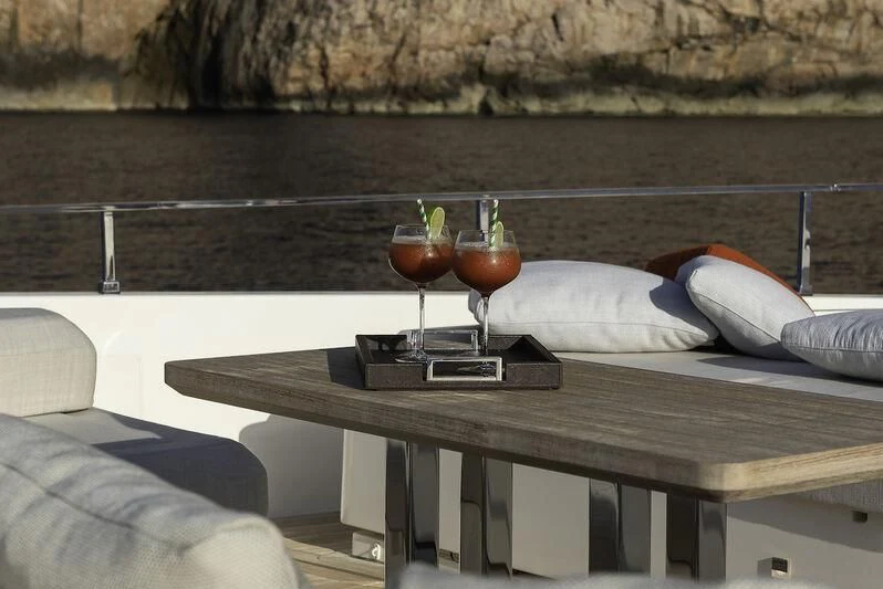 a table with a glass and a tray with food on it aboard DIANA II Yacht for Sale