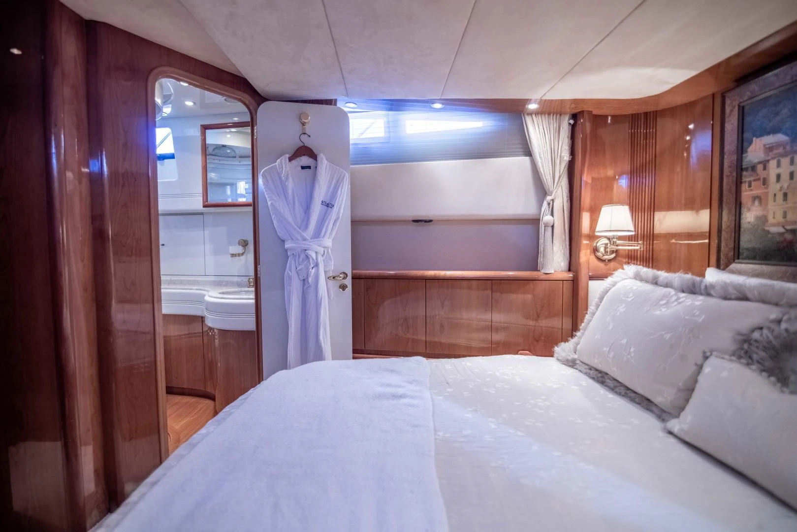 a bed with a robe on the wall aboard ENCHANTED LADY Yacht for Sale