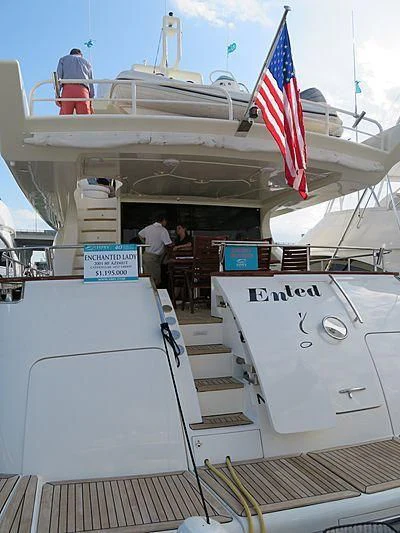 a boat with a flag on the front aboard ENCHANTED LADY Yacht for Sale