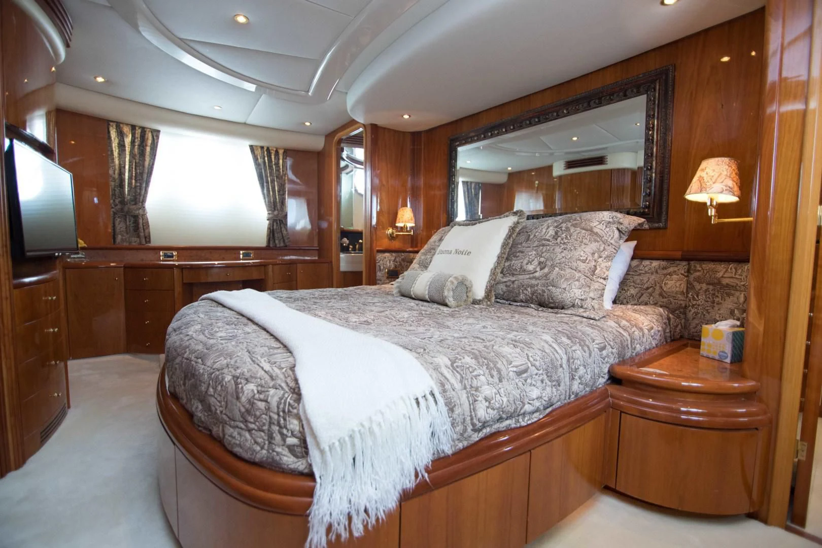 a bed with a white sheet and pillows in a room with wood walls aboard ENCHANTED LADY Yacht for Sale